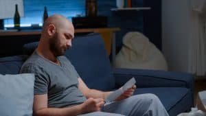 A man sitting on a couch reading a document