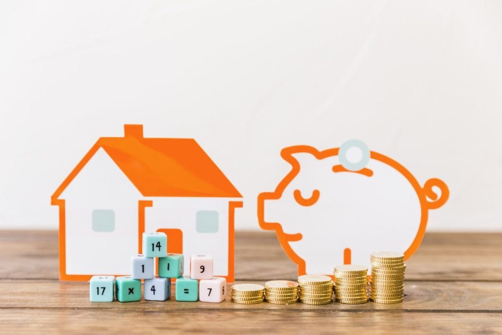 An orange house outline and piggy bank with stacked coins and number blocks