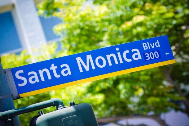 A Santa Monica Boulevard street sign among green trees