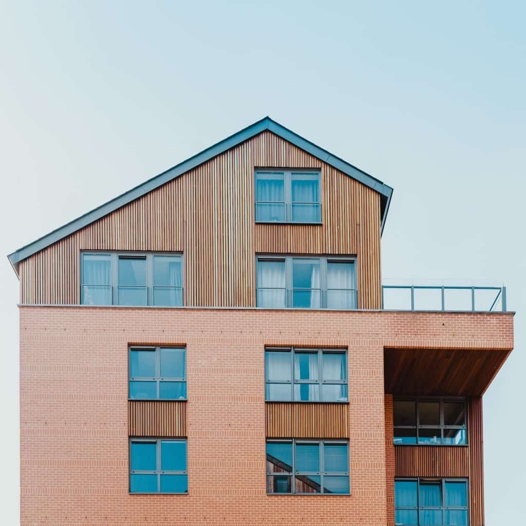 A modern multi-story house with wood siding and a peaked roof