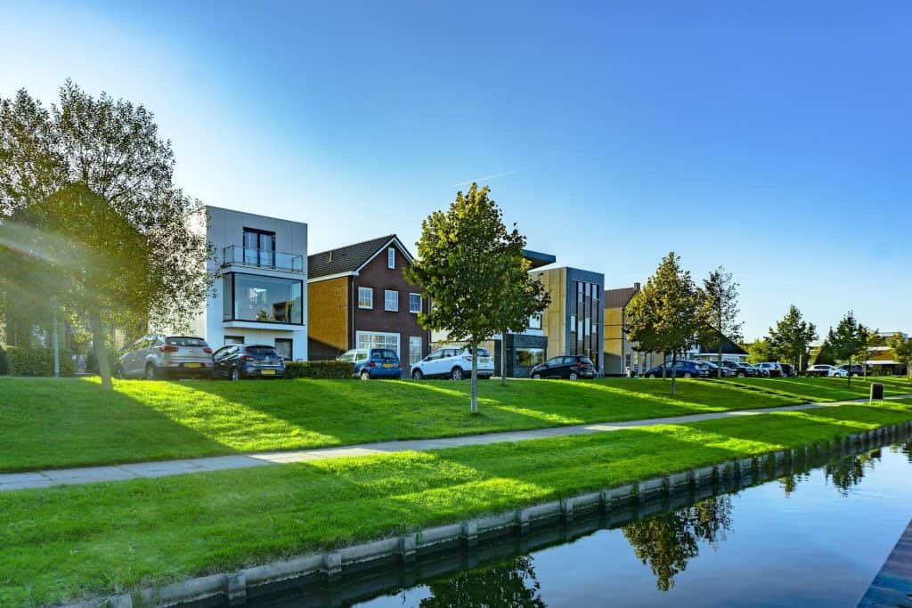 Modern colorful apartment buildings beside a lawn and canal