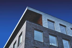 Low-angle view of a modern apartment building against a blue sky