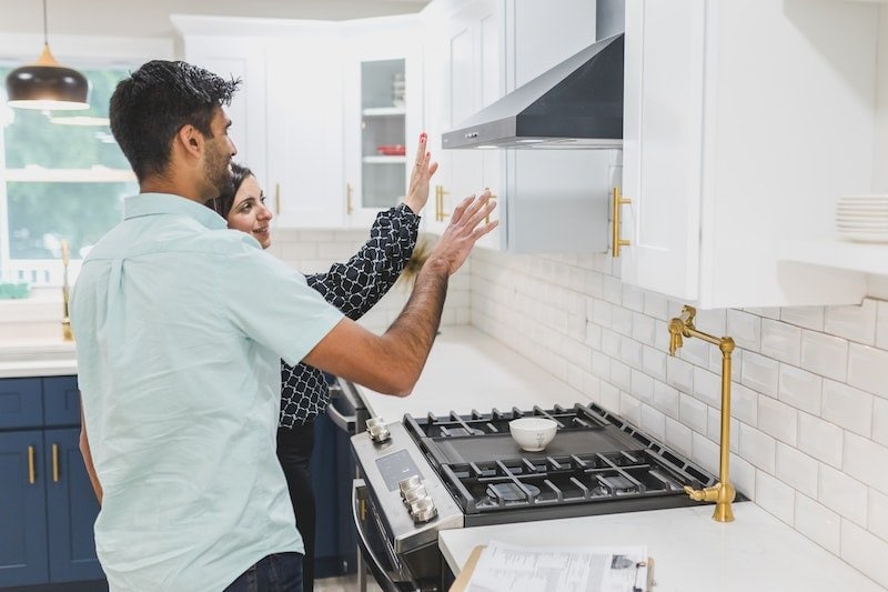 A man and woman having a discussion in a kitchen