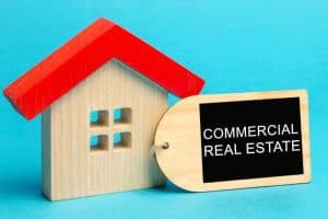 A wooden model house with a Commercial Real Estate tag