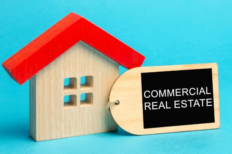 A wooden model house with a Commercial Real Estate tag