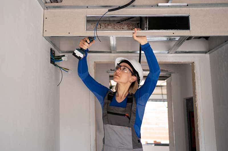Technician inspecting a broken air conditioner in a California rental