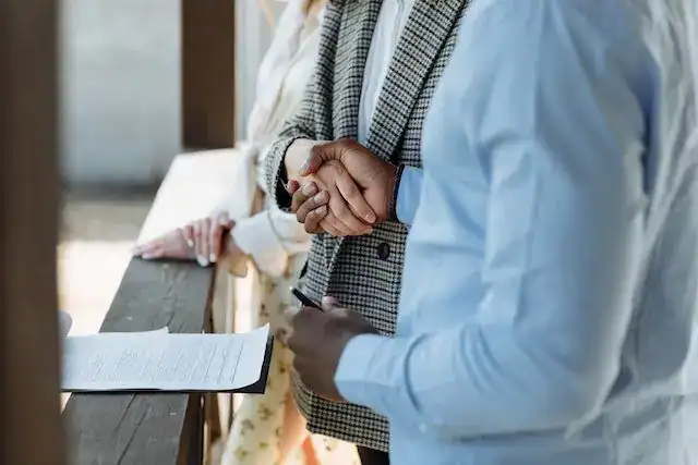 One person handing a folded document to another during a rental discussion